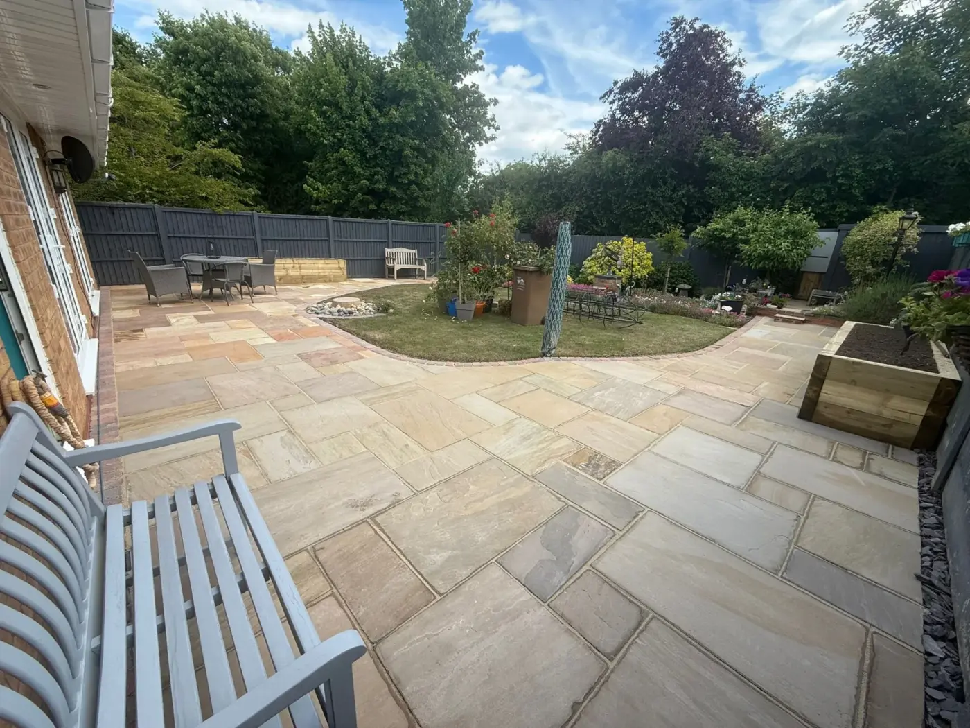Sandstone patio with bench and garden in Redditch
