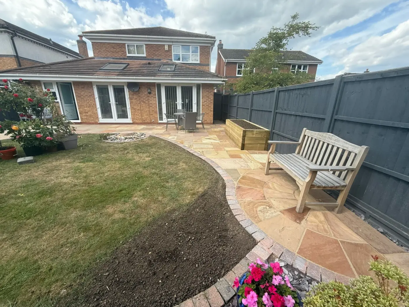 Sandstone patio with wooden bench and garden remodel