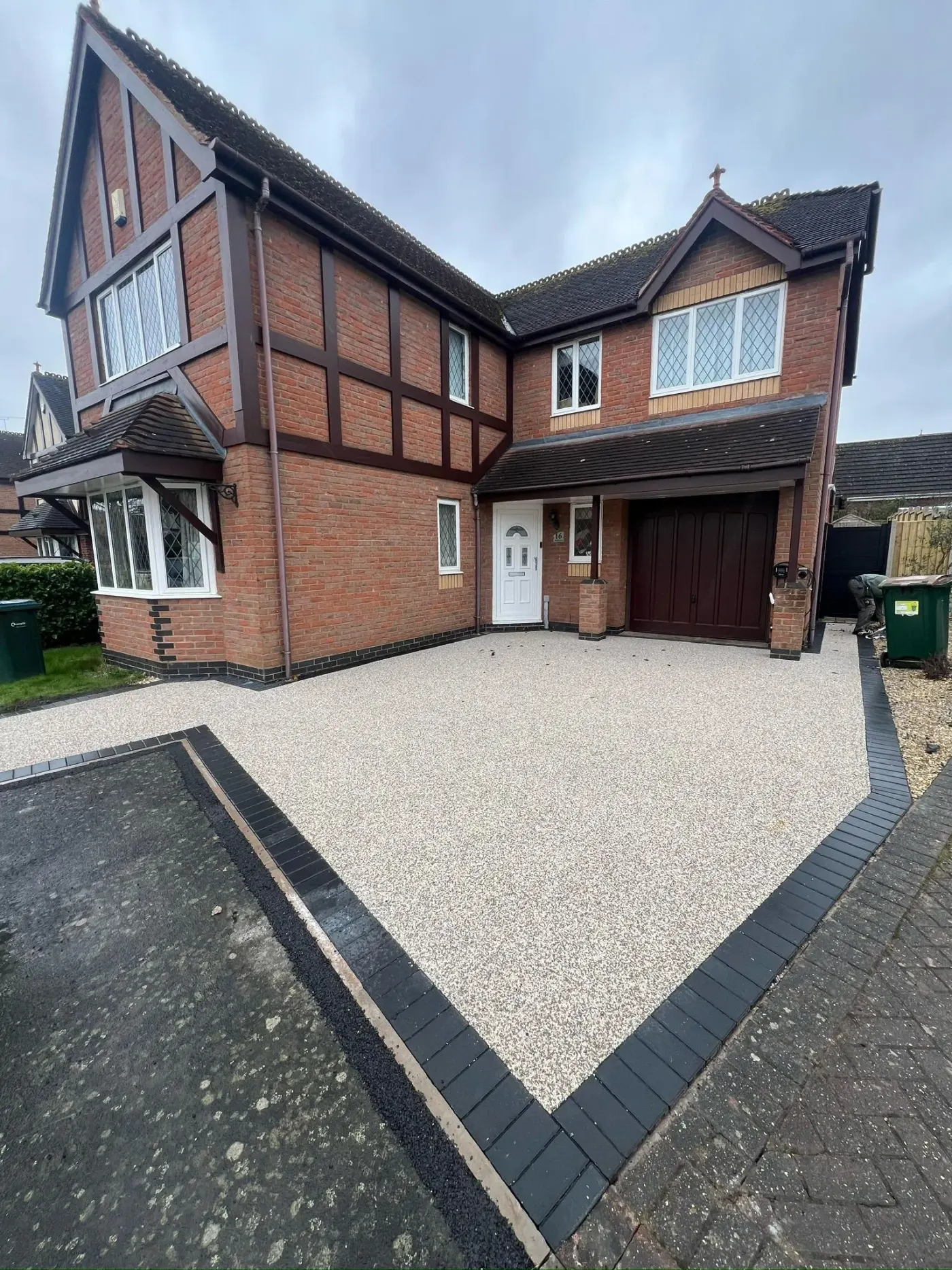 Resin bound driveway with brick border laid by Seastone at a Tudor-style home in Worcestershire